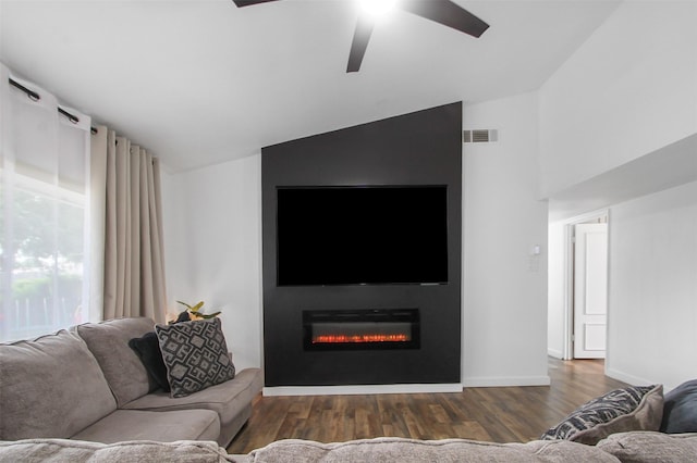 917 Park E Cir, Garland, TX 75043 - living area featuring lofted ceiling, a glass covered fireplace, wood finished floors, ceiling fan, and baseboards