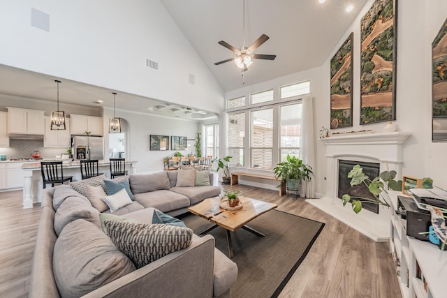233 Honey Brook Ln, Aledo, TX 76008 - living room with high vaulted ceiling, a ceiling fan, a glass covered fireplace, and light wood finished floors