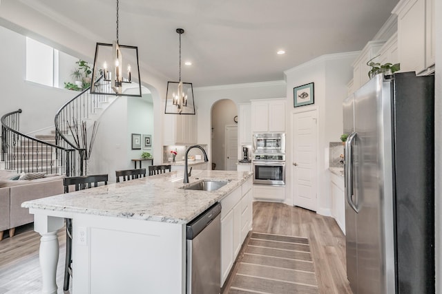 233 Honey Brook Ln, Aledo, TX 76008 - kitchen with appliances with stainless steel finishes, a sink, a kitchen bar, arched walkways, and white cabinetry