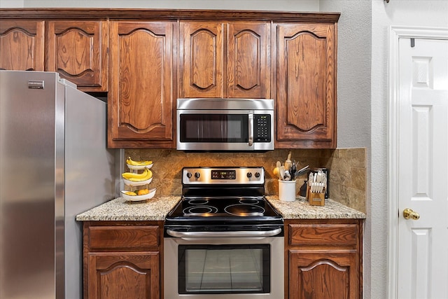 110 Stanford, Forney, TX 75126 - kitchen featuring stainless steel appliances, tasteful backsplash, a textured wall, and light stone countertops