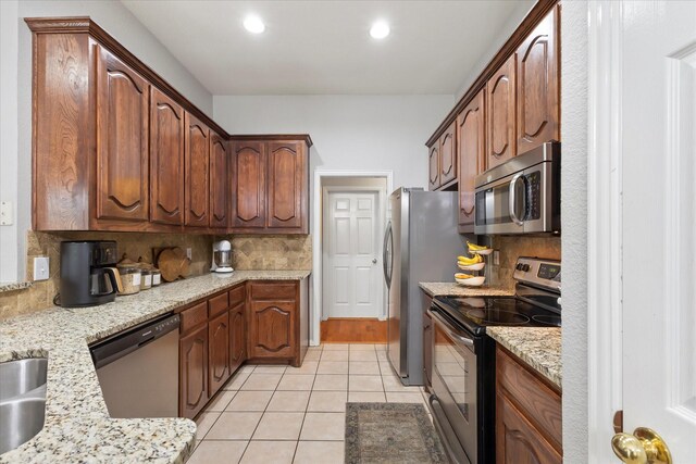 110 Stanford, Forney, TX 75126 - kitchen with stainless steel appliances, decorative backsplash, light tile patterned flooring, recessed lighting, and light stone countertops
