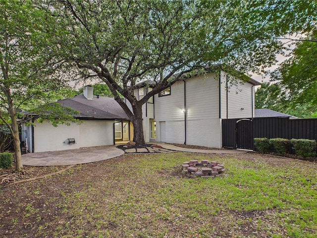 7323 Whispering Pines Dr, Dallas, TX 75248 - rear view of property featuring an outdoor fire pit, brick siding, a patio area, and a gate