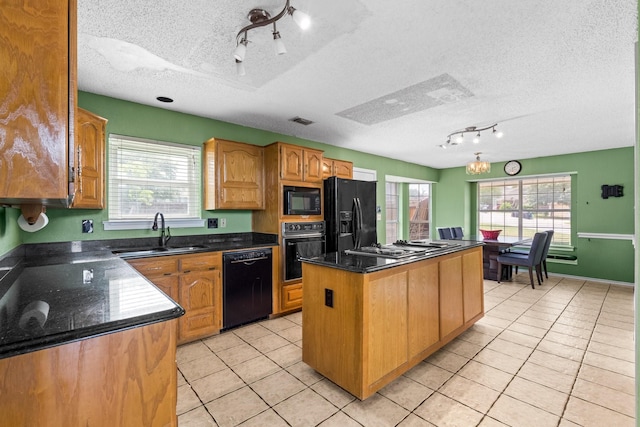 10201 Buffalo Grove Rd, Fort Worth, TX 76108 - kitchen with black appliances, a sink, rail lighting, a textured ceiling, and a kitchen island