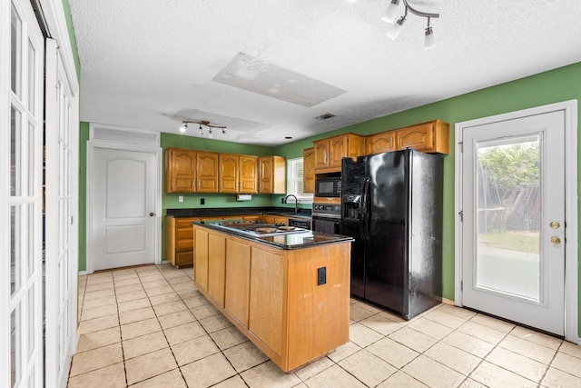 10201 Buffalo Grove Rd, Fort Worth, TX 76108 - kitchen with black appliances, track lighting, a textured ceiling, a center island, and light tile patterned flooring