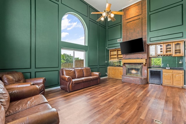 10201 Buffalo Grove Rd, Fort Worth, TX 76108 - living room featuring a decorative wall, wet bar, ceiling fan, light wood-style floors, and a brick fireplace