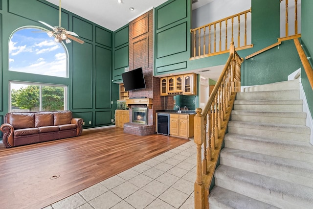 10201 Buffalo Grove Rd, Fort Worth, TX 76108 - living room featuring stairs, ceiling fan, light tile patterned floors, a fireplace, and a decorative wall