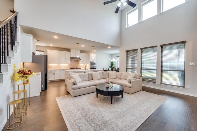 624 Cedarwood St, Little Elm, TX 76227 - living room featuring a towering ceiling, dark wood-style flooring, a ceiling fan, stairs, and recessed lighting