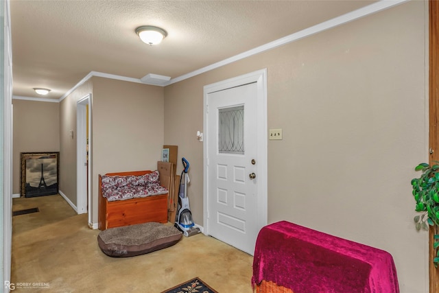 foyer featuring crown molding, carpet flooring, a textured ceiling, and baseboards