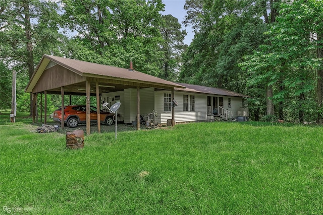 rear view of house with a carport, entry steps, a lawn, and metal roof