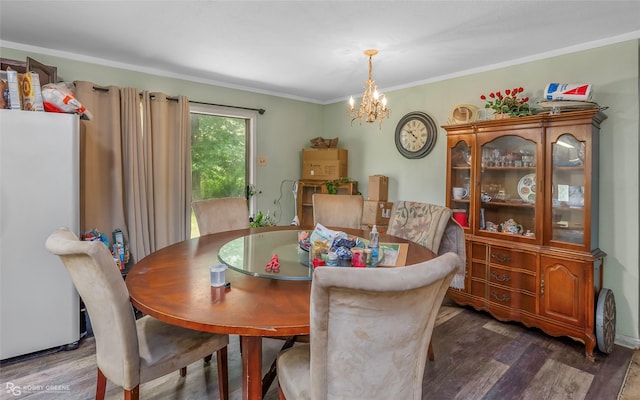 dining room with dark wood-style flooring, a chandelier, and ornamental molding
