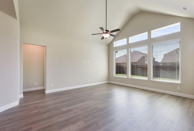 unfurnished room with a ceiling fan, wood finished floors, high vaulted ceiling, and baseboards