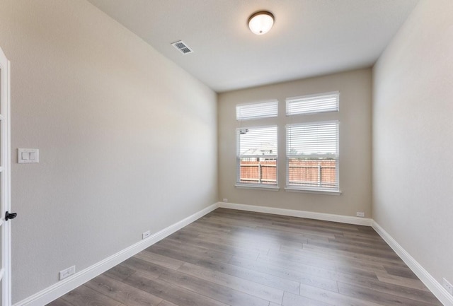 spare room with dark wood-style flooring and baseboards