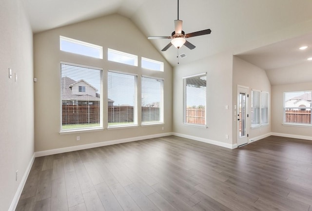 spare room with vaulted ceiling, a ceiling fan, dark wood-type flooring, and baseboards