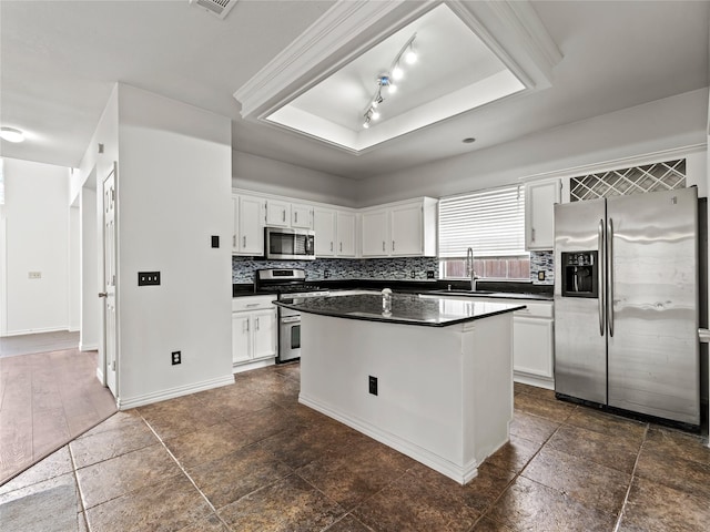 3000 Clearmeadow Dr, Mesquite, TX 75181 - kitchen featuring stainless steel appliances, a sink, a tray ceiling, dark countertops, and a kitchen island