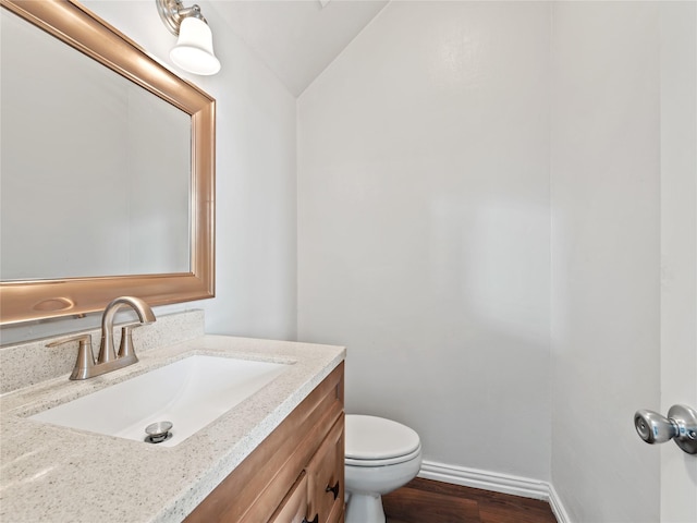 3000 Clearmeadow Dr, Mesquite, TX 75181 - half bathroom featuring vaulted ceiling, baseboards, vanity, toilet, and wood finished floors