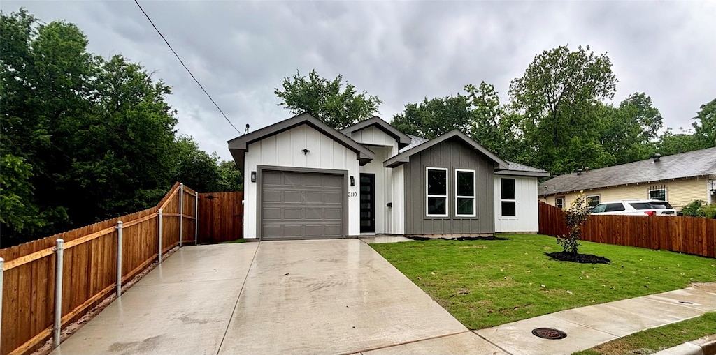 3110 Tuskegee St, Dallas, TX 75215 - view of front facade with an attached garage, driveway, and board and batten siding