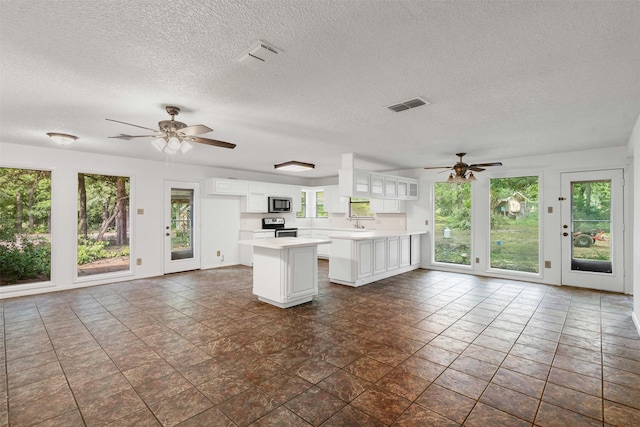 104 Murls Lake Rd, Weatherford, TX 76085 - kitchen with appliances with stainless steel finishes, a ceiling fan, light countertops, a textured ceiling, and open floor plan