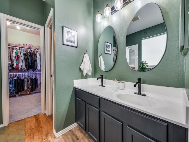 976 Fox Grove Ln, Providence Village, TX 76227 - full bath featuring wood finished floors, a textured wall, double vanity, a spacious closet, and baseboards
