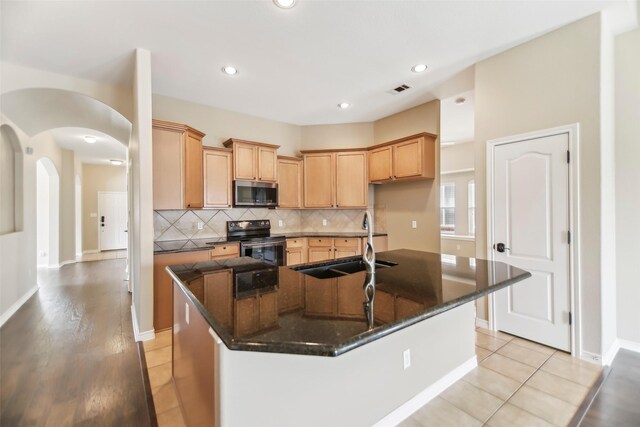 5900 Pansy Rd, Fort Worth, TX 76123 - kitchen with appliances with stainless steel finishes, a sink, decorative backsplash, an island with sink, and dark stone counters