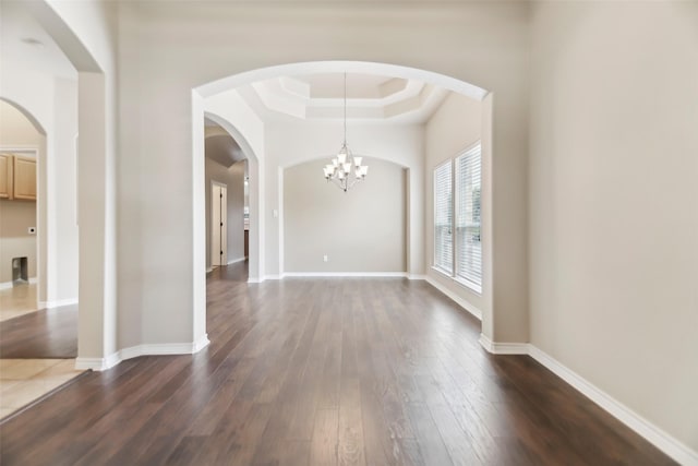 5900 Pansy Rd, Fort Worth, TX 76123 - empty room with a tray ceiling, dark wood finished floors, a chandelier, and baseboards