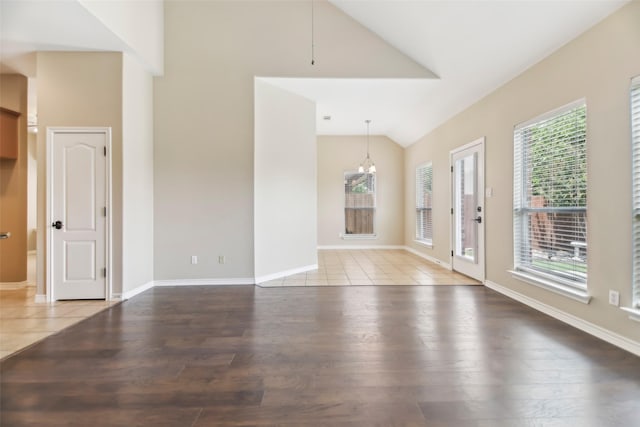 5900 Pansy Rd, Fort Worth, TX 76123 - unfurnished living room featuring wood finished floors, a chandelier, baseboards, and high vaulted ceiling