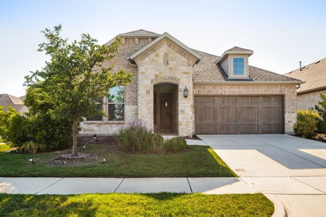 3000 Culver Ave, Celina, TX 75009 - french country home with stone siding, an attached garage, driveway, and brick siding