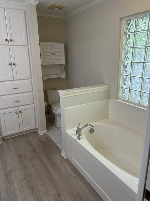 301 Village Cir, Waco, TX 76710 - bathroom featuring ornamental molding, a bath, plenty of natural light, toilet, and wood finished floors