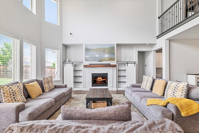 2540 Bottlebrush Dr, Prosper, TX 75078 - living area featuring a towering ceiling, a fireplace, wood finished floors, and built in shelves