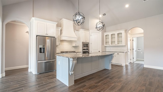 kitchen with stainless steel appliances, arched walkways, baseboards, high vaulted ceiling, and white cabinetry