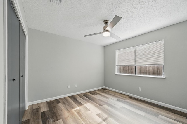 8805 Wood Glen Dr, Rowlett, TX 75088 - unfurnished bedroom with a closet, wood finished floors, a textured ceiling, baseboards, and ceiling fan