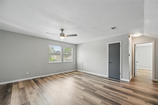 8805 Wood Glen Dr, Rowlett, TX 75088 - empty room with wood finished floors, a ceiling fan, a textured ceiling, and baseboards