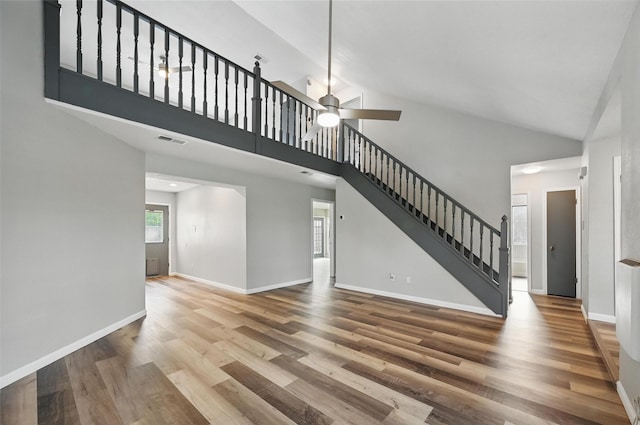 8805 Wood Glen Dr, Rowlett, TX 75088 - unfurnished living room featuring wood finished floors, stairway, baseboards, a ceiling fan, and high vaulted ceiling