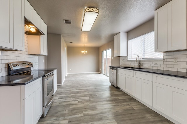4032 Red Rock, Heartland, TX 75126 - kitchen featuring stainless steel appliances, a sink, dark countertops, a textured ceiling, and baseboards