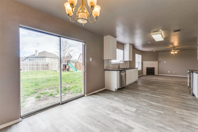 4032 Red Rock, Heartland, TX 75126 - kitchen featuring a sink, dark countertops, dishwasher, a chandelier, and a fireplace