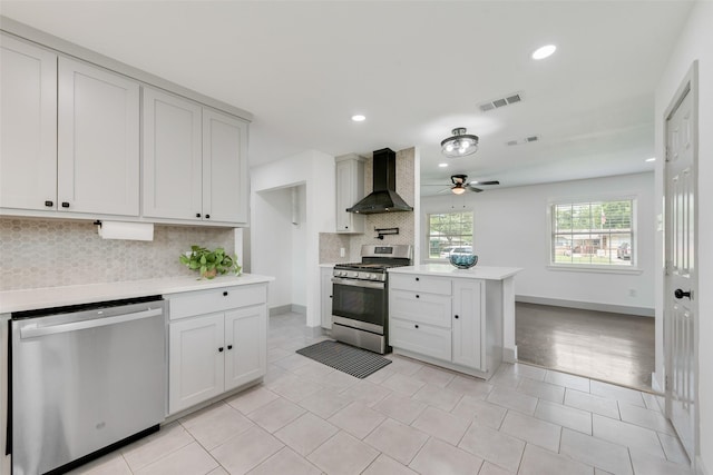 10166 San Lorenzo Dr, Dallas, TX 75228 - kitchen featuring wall chimney exhaust hood, appliances with stainless steel finishes, light countertops, decorative backsplash, and a ceiling fan