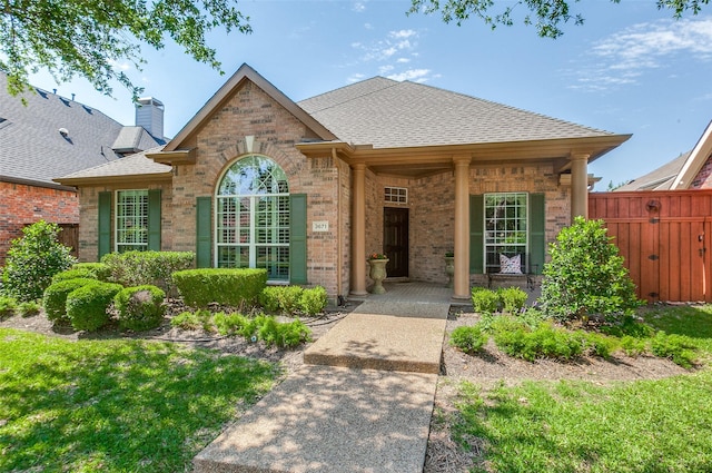 3671 Navarro Way, Frisco, TX 75034 - view of front of home featuring brick siding, roof with shingles, fence, and a chimney