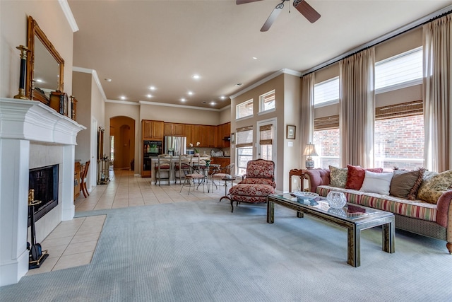 3671 Navarro Way, Frisco, TX 75034 - living area with arched walkways, light tile patterned floors, ornamental molding, ceiling fan, and a tile fireplace