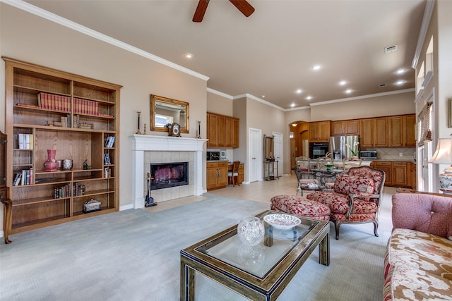 3671 Navarro Way, Frisco, TX 75034 - living area with ceiling fan, a tiled fireplace, recessed lighting, light carpet, and ornamental molding