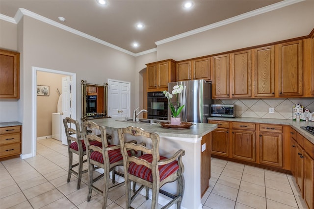 3671 Navarro Way, Frisco, TX 75034 - kitchen featuring a sink, appliances with stainless steel finishes, light tile patterned flooring, a breakfast bar, and crown molding