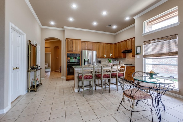 3671 Navarro Way, Frisco, TX 75034 - kitchen with stainless steel fridge with ice dispenser, arched walkways, crown molding, backsplash, and a kitchen island