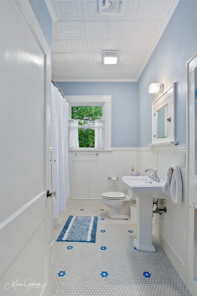 full bath featuring toilet, tile patterned flooring, a wainscoted wall, an ornate ceiling, and a shower with curtain