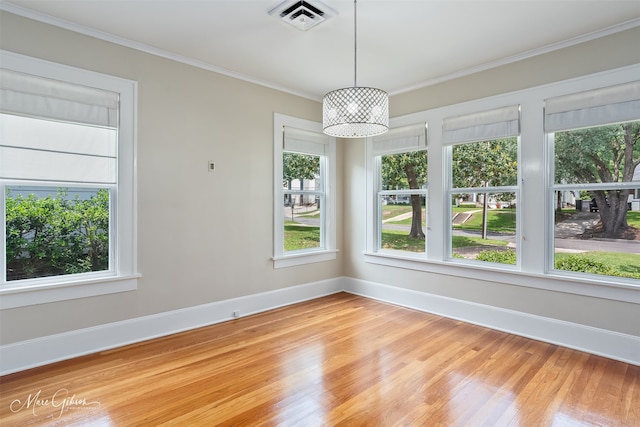 unfurnished room featuring light wood-style flooring, baseboards, and crown molding