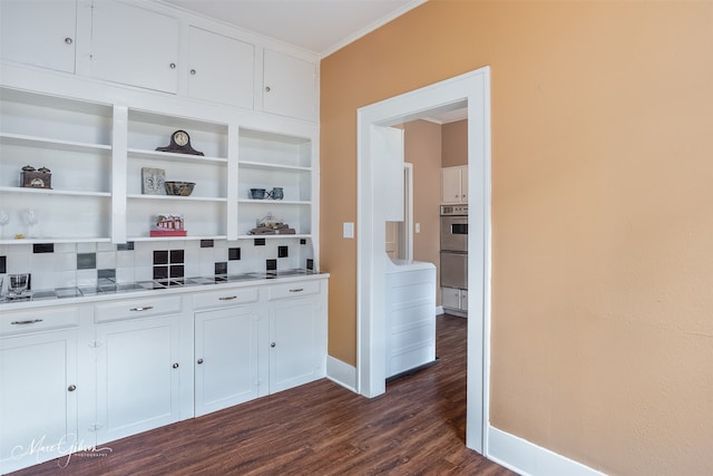 hall with dark wood-type flooring, ornamental molding, and baseboards