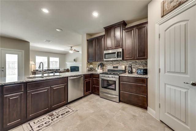 3804 Tunstall Dr, Frisco, TX 75036 - kitchen featuring stainless steel appliances, a sink, ceiling fan, dark brown cabinets, and tasteful backsplash