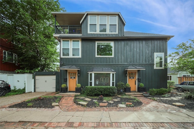 view of front of property with a balcony, driveway, and a garage