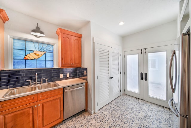 kitchen featuring stainless steel appliances, a sink, healthy amount of natural light, light countertops, and recessed lighting