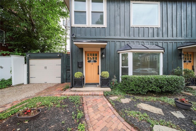 view of front facade featuring board and batten siding, a garage, and dirt driveway