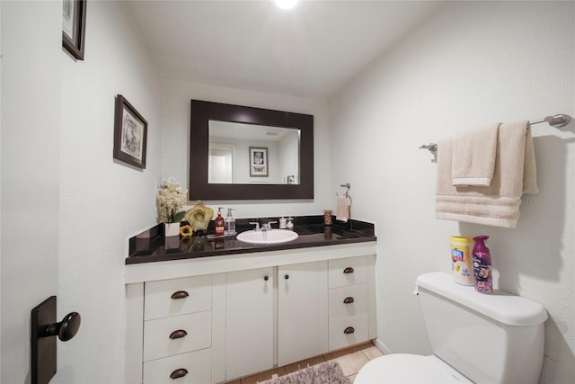 half bathroom with toilet, vanity, and tile patterned flooring