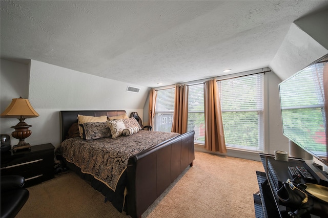 bedroom featuring a textured ceiling, lofted ceiling, and light colored carpet