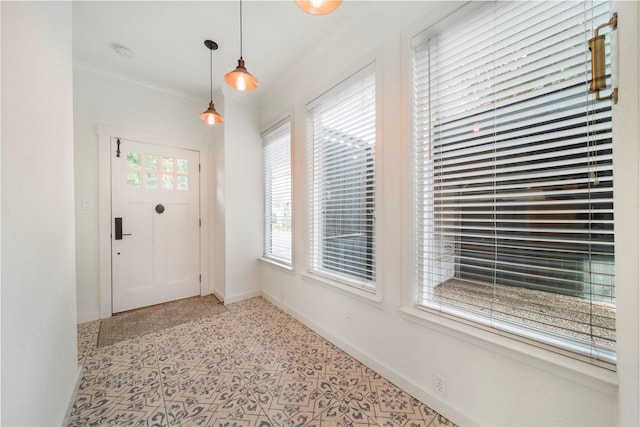 foyer entrance featuring ornamental molding and baseboards